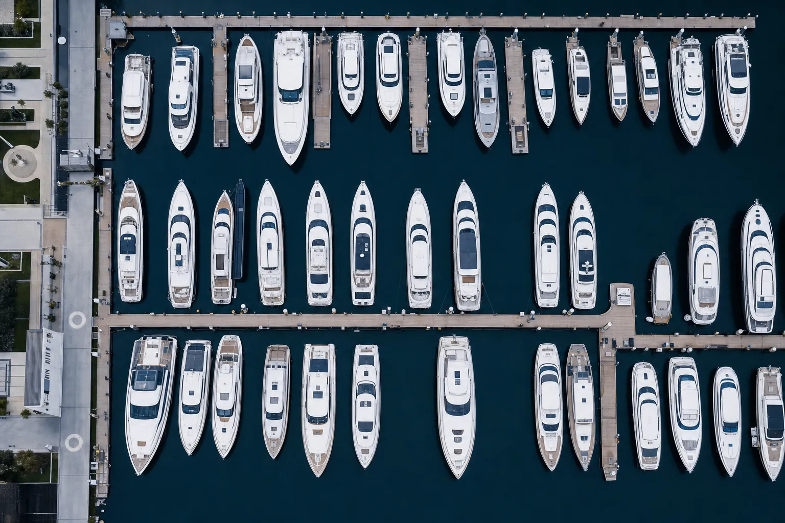 Aerial view of a marina with rows of moored motor yachts